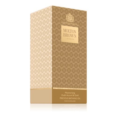 En lång, rektangulär, guldfärgad låda med mönster, en krona och texten 'Molton Brown London'.