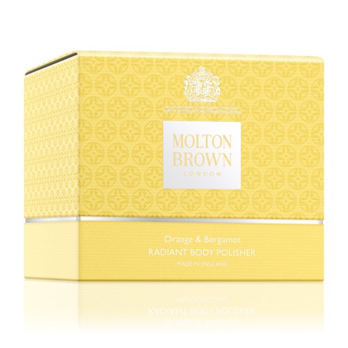 Gul låda med vit och guld text, märkt Molton Brown, som innehåller strålande kroppsskrubb med apelsin och bergamott dofter.