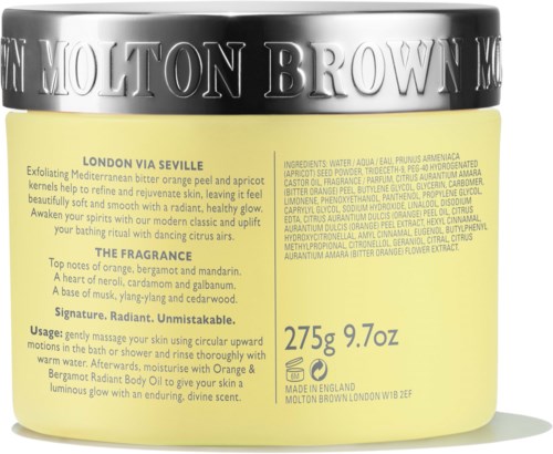 Gul behållare med svart lock, innehåller Molton Brown kroppslotion, med ingredienser, användning och doftbeskrivning i liten text.