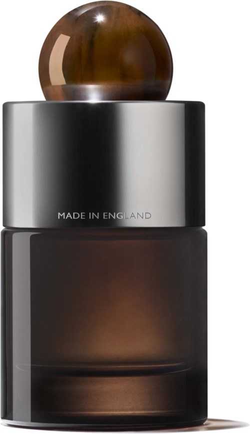 En mörk glasflaska med metalllock och en brunsfärgad rund topp, märkt "Made in England."