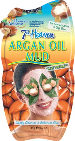 Et ansiktsmaskeprodukt med arganolje, som viser en smilende kvinne med blader og leire i ansiktet, omgitt av nøtter.