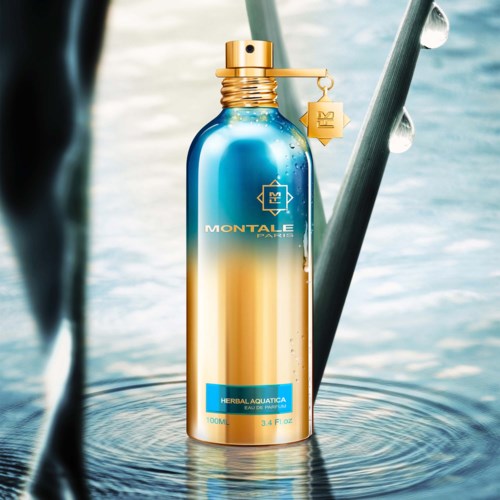 Eine blaugoldene Sprühflasche mit einem Markennamen, auf Wasser mit Tropfen und Pflanzen rund.
