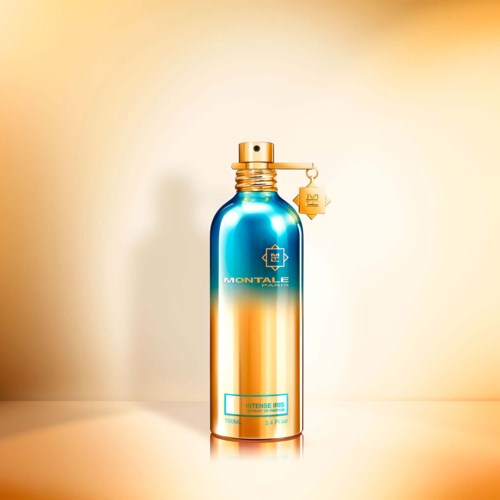 Eine blaue und goldene Sprühflasche mit goldener Kappe, Etikett und Logo, vor hellem Hintergrund.