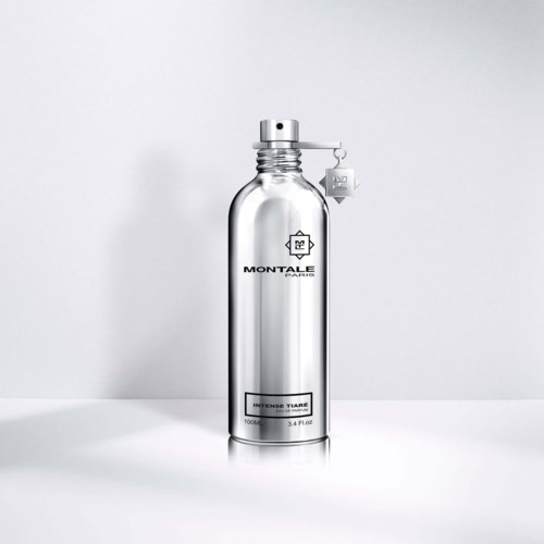 Eine glänzende silberne Flasche mit einem Etikett, auf dem 'Montale Paris' und 'Intense Tiare' steht, steht auf einer weißen Oberfläche.