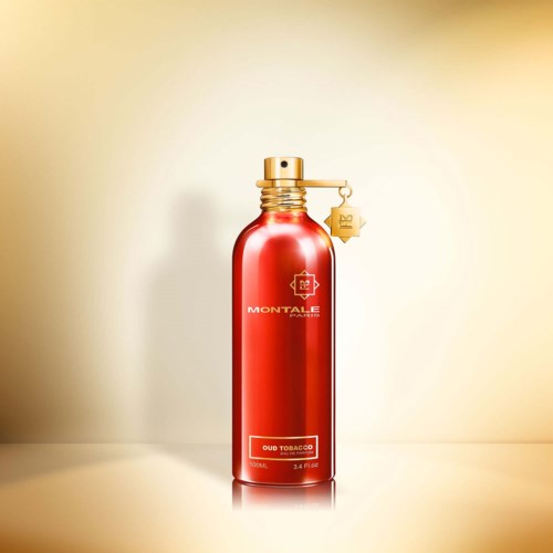 Een rode, glanzende fles met een gouden dop en een kleine hanger, gemarkeerd met MONTALe en de geur Duob Tobacco.
