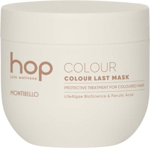 En vit burk med rosa text som marknadsför en hårmask för färgat hår, innehållande alger och ferulinsyra.