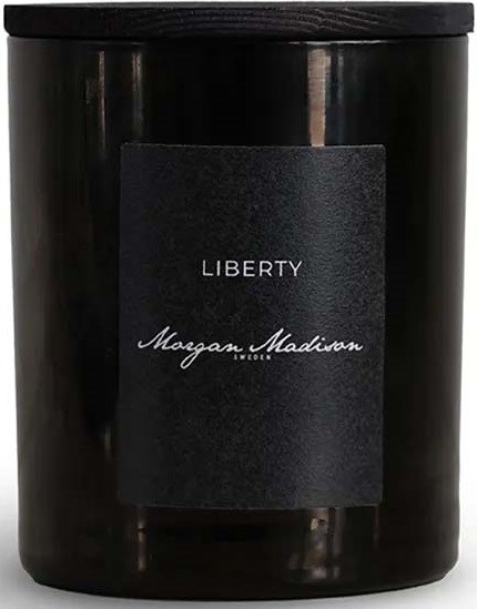 Czarny słoik na świecę z etykietą z napisem 'Liberty' i 'Megan Madison' w pisowni kursywą.