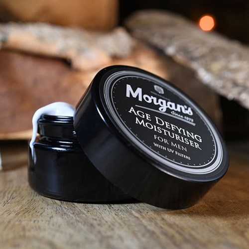 En svart burk med Morgan's Age Defying Moisturiser för män på en träyta.