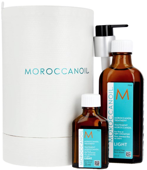 Två bruna flaskor med vita lock och en vit pump, alla märkta Moroccanoil Light, bredvid en vit cylinderformad låda.
