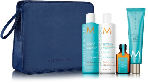 Sininen matkakassi, jossa on neljä MOROCCANOIL-tuotetta, kuten shampoota, hoitoainetta, käsivoidetta ja pieni pullo.