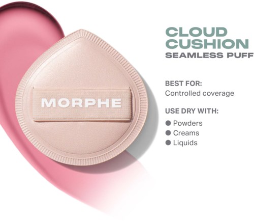 A round, pink cushion with a beige cover labeled MORPHE, used for makeup application, with text describing its use and best for coverage.