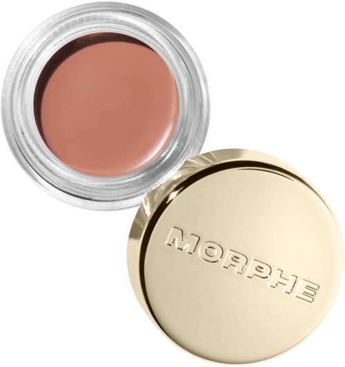 En liten beholder med beige sminke og gullfarget lokk merket "Glossier".