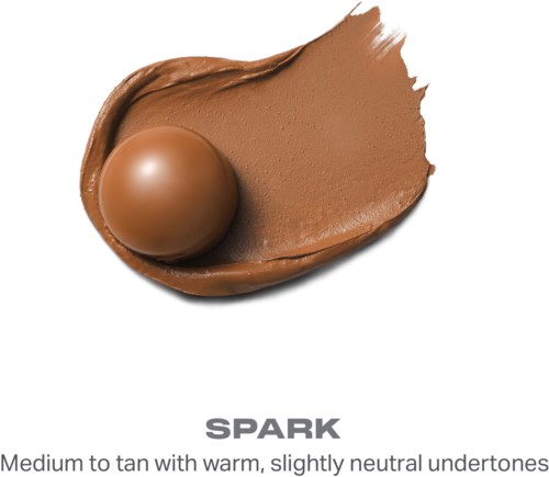 Ett brunt sminkprodukt med sfärisk form, slät textur och en provning som visar en mediumbrun nyans.