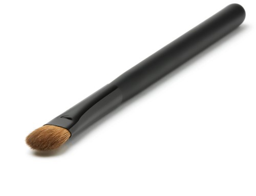 En makeupborste med svart handtag och bruna borst.