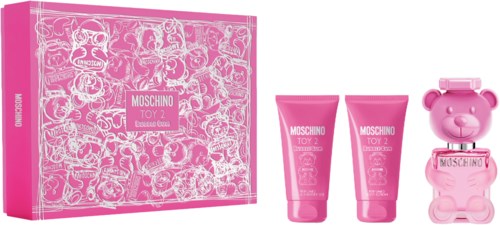 Pink box with cartoon faces, two pink tubes labeled Moschino Toy, and a pink bear-shaped item.
