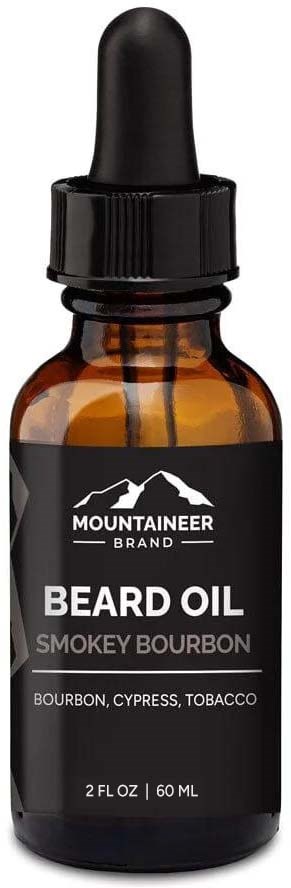 Mała brązowa butelka olejku do brody z czarną zakrętką i etykietą. Etykieta mówi "Mountaineer Beard Oil" i wymienia zapachy.