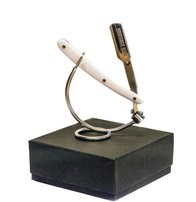 En roboticarm på en svart box, håller ett litet föremål med en vit kabel.