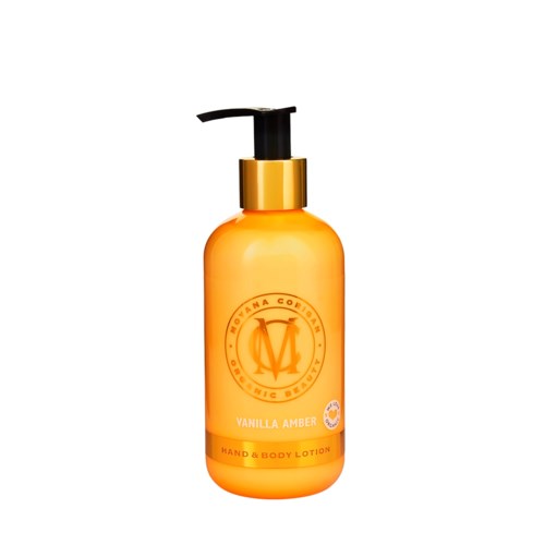 En lysende oransje lotionflaske med svart pumpe, merket 'Vanilla Amber' hånd- og kroppslotion.