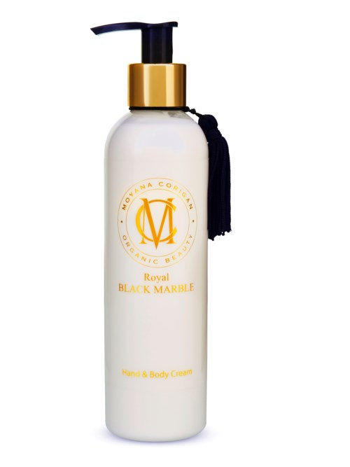Vit flaska med svart pump, guldring och svart tofs. Etiketten säger 'Royal Black Marble Hand & Body Cream'.
