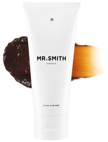 En hvit tubes med merket 'MR. SMITH Chestnut' med mørke og lyse brune bakgrunner bak den.