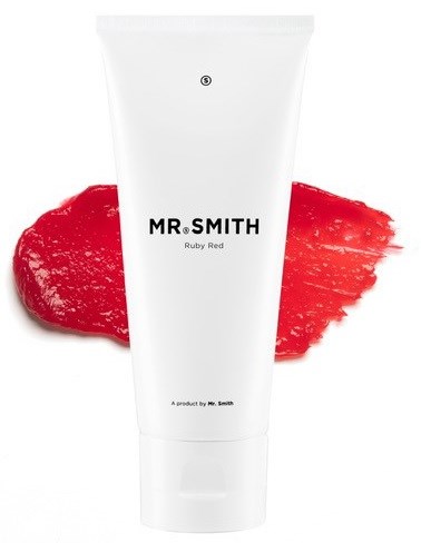 En hvit tube med svart tekst, kalt Mr. Smith Ruby Red, står foran en rød malingflekk.