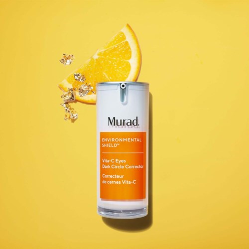 A white bottle labeled Murad with orange label, lemon wedge, and small crystals on a bright yellow background.