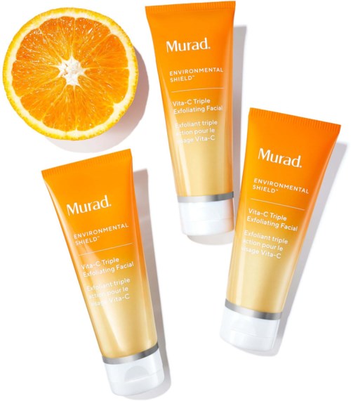 Drie oranje tubes gezichtscrub en een halve sinaasappel. De tubes hebben labels met het merk Murad en productgegevens.