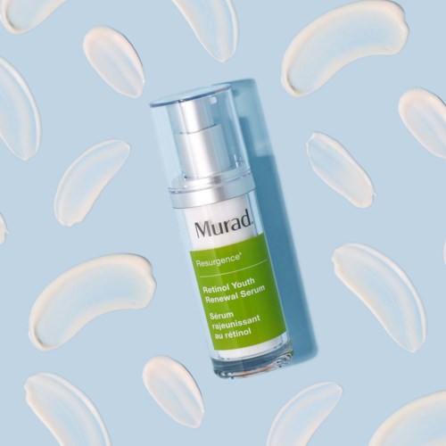 A skincare serum bottle surrounded by white, curved cosmetic capsules on a blue background.