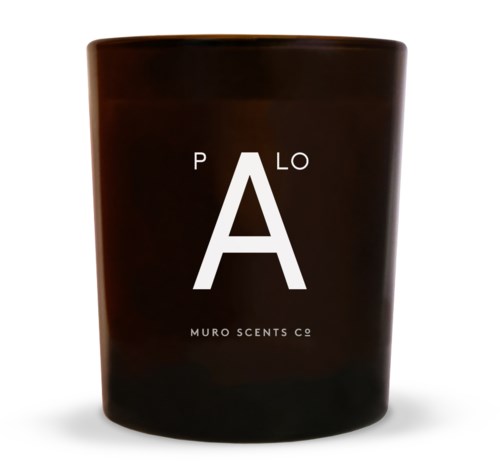 Ett mörkbrunt ljus med orden 'PLANO' och 'MURO SCENTS CO' skrivna på i vitt.