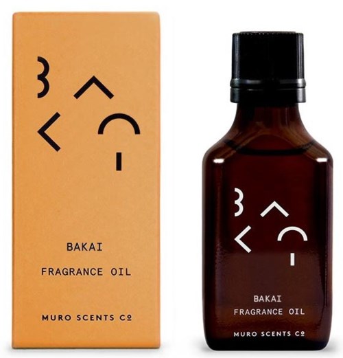 En liten brun flaska med svart lock och en matchande orange låda, båda märkta 'Bakw Fragrance Oil' av Muro Scents.