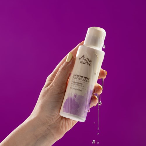 A hand holds a white bottle labeled 'Make Me Melt' with purple paint at the bottom and purple background.