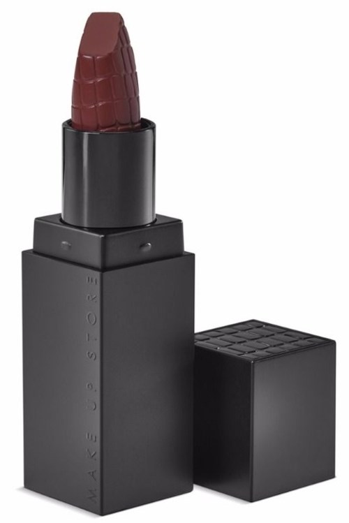 A lipstick in a black square case with a deep red color and textured surface.