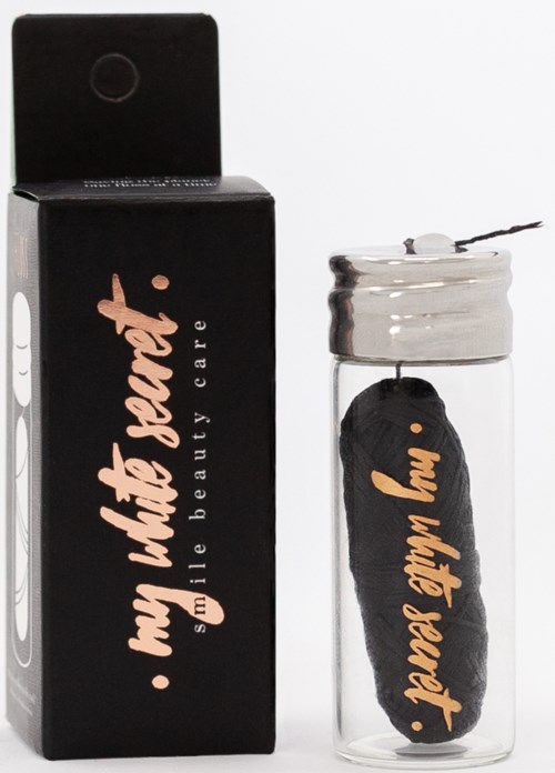 En liten burk med en svart svamp inuti, bredvid en svart box med rosa text som säger "My little art."