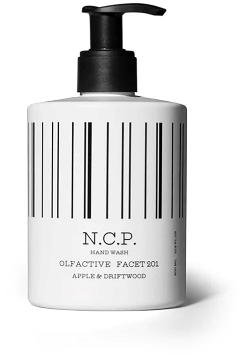En vit flaska med svart pump, märkt N.C.P. Hand Wash, doft Apple & Driftwood, med vertikala linjer.