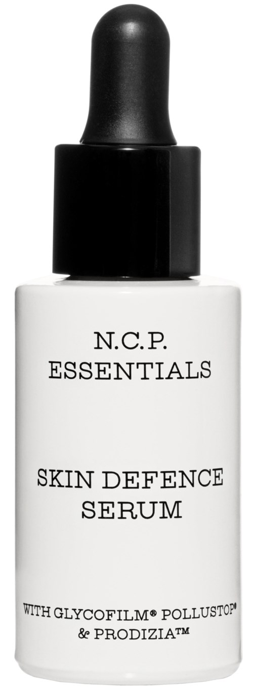 En hvit flaske med svart dryppkork merket 'N.C.P. ESSENTIALS Skin Defence Serum'.