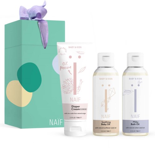 Eine Geschenkbox mit lila Band, zwei Babypflegeflaschen und eine Windelcreme in sanften Farben.