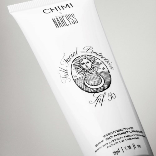 En hvit tube med svart tekst og en sol og måne logo, merket som ansiktsbeskyttende lotion.