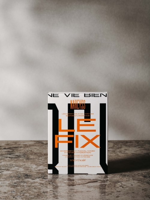 Bok med tittelen "Le Fix" står på et teksturert bord mot en enkel vegg bakgrunn.