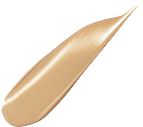 Et beige skjønnhetsprodukt påført, formet som en tåre, glatt og skinnende.