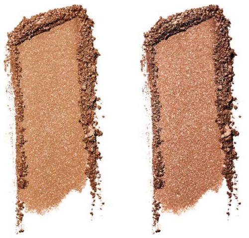 Två swatches av skimrande bronsfärgad makeup-puder, en med sprucken kant, på vit bakgrund.