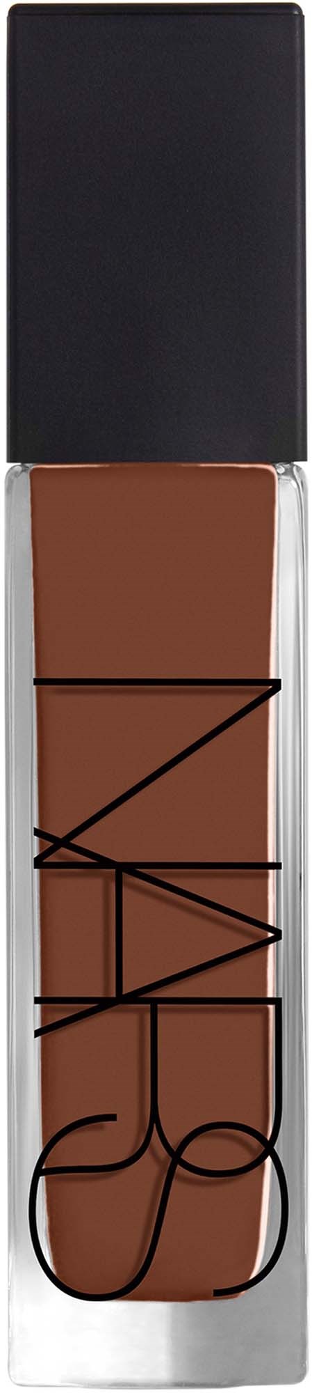 NARS flydende foundationflaske med sort låg, gennemsigtig krop med brunt produkt, mærke på forsiden, mod sort baggrund.