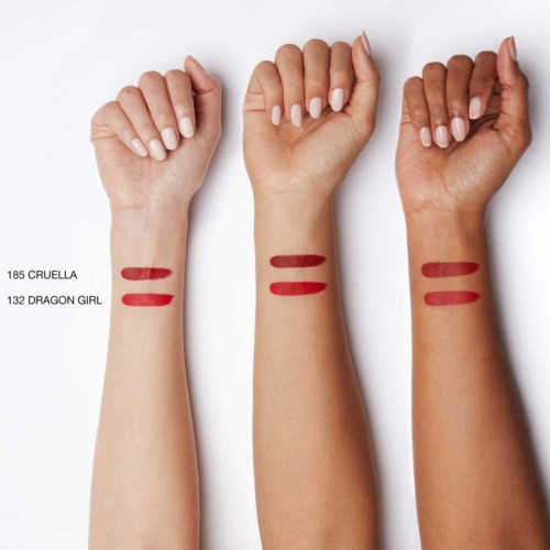 Three arms show different skin tones with matching red lipstick swatches and labels: 185 Cruella and 132 Dragon Girl.