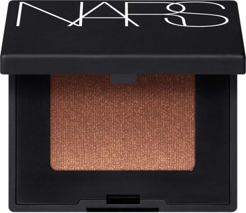 NARS ögonskugga i en glittrig brun nyans i en svart förpackning med genomskinligt lock.