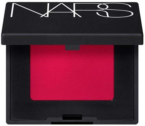 En svart kompakt makeuppuderbehållare med röd rouge inuti. Locket har märket NARS skrivet på sig.