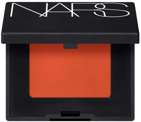 En NARS-ögonskuggspalett med orange pulver inuti. Det svarta locket har en vit NARS-logga.