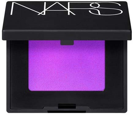 En NARS rougeförpackning med lila rouge inuti, svart hölje och vitt NARS-tryck på locket.