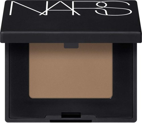 En liten NARS makeup-produkt med svart lock och beige puder inuti.