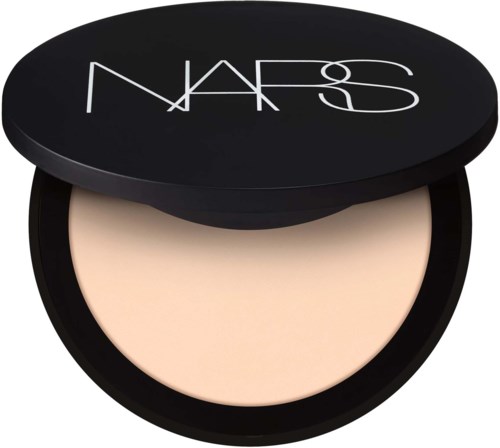 En rund svart beholder med et beige pulver inni og NARS-logo på lokket.