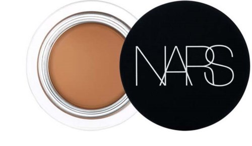 Ett litet runt burk med ljusbrun kräm och ett svart lock med NARS-logotypen i vitt.