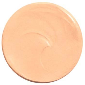Ein runder, hellbeiger Kompakt mit etwas Creme oder Foundation drin und einem Wirbelmuster.